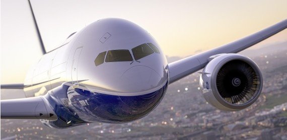 A close-up of an airplane flying over the city, raising the question, What is airplane mode used for during a flight.